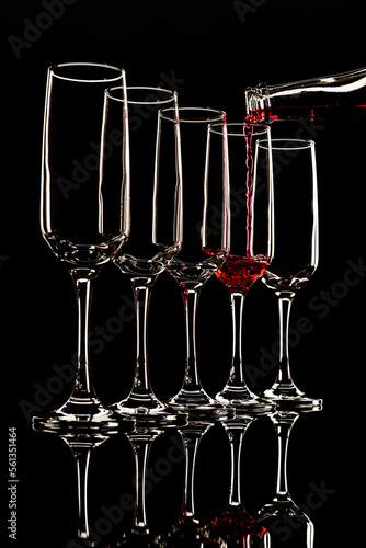 glass goblets outlined with light on a black background