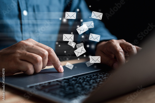 Businessman sending email by laptop computer  to customer, business contact and communication, email icon, email marketing concept, send e-mail or newsletter, online working internet network. photo