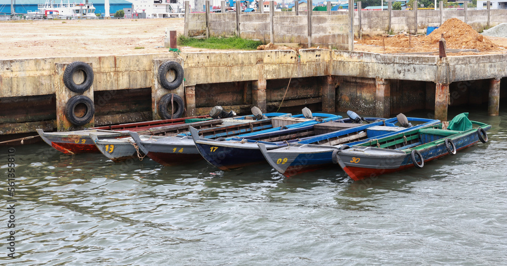 Six small wooden fishing boat docking at the pier.