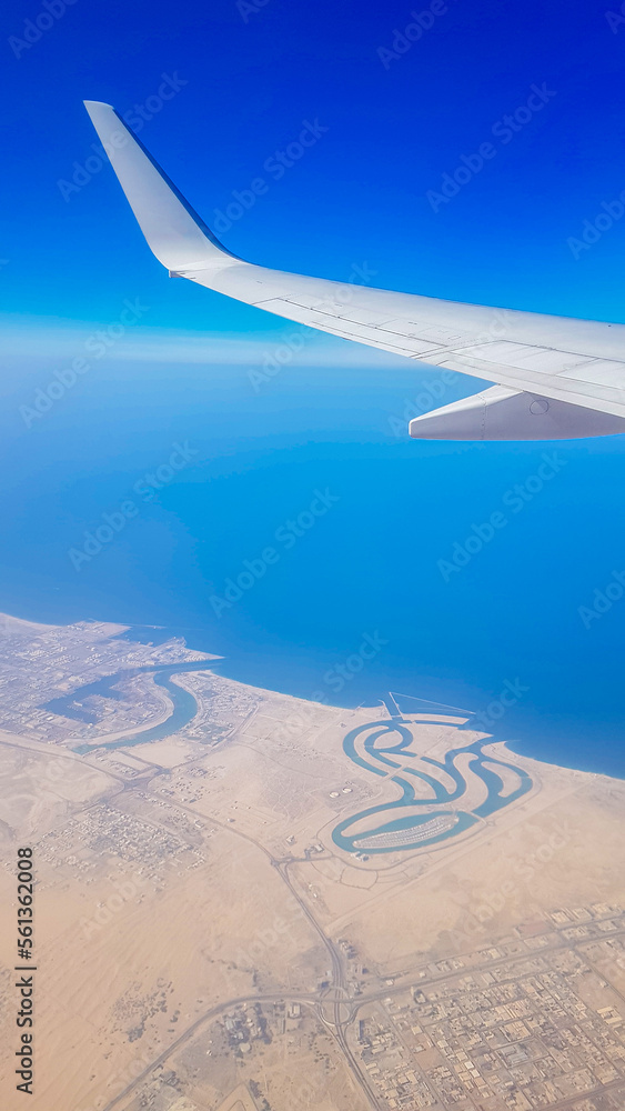 View from the window of plane on blue sky and earth with landscape of desert, sea and canals in Emirates. High quality photo View from the window of plane on blue sky and earth with landscape of desert, sea and canals in Emirates. High quality photo