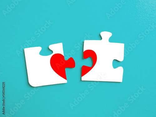 Two separated pieces of a puzzle on a turquoise background with a blank space photo