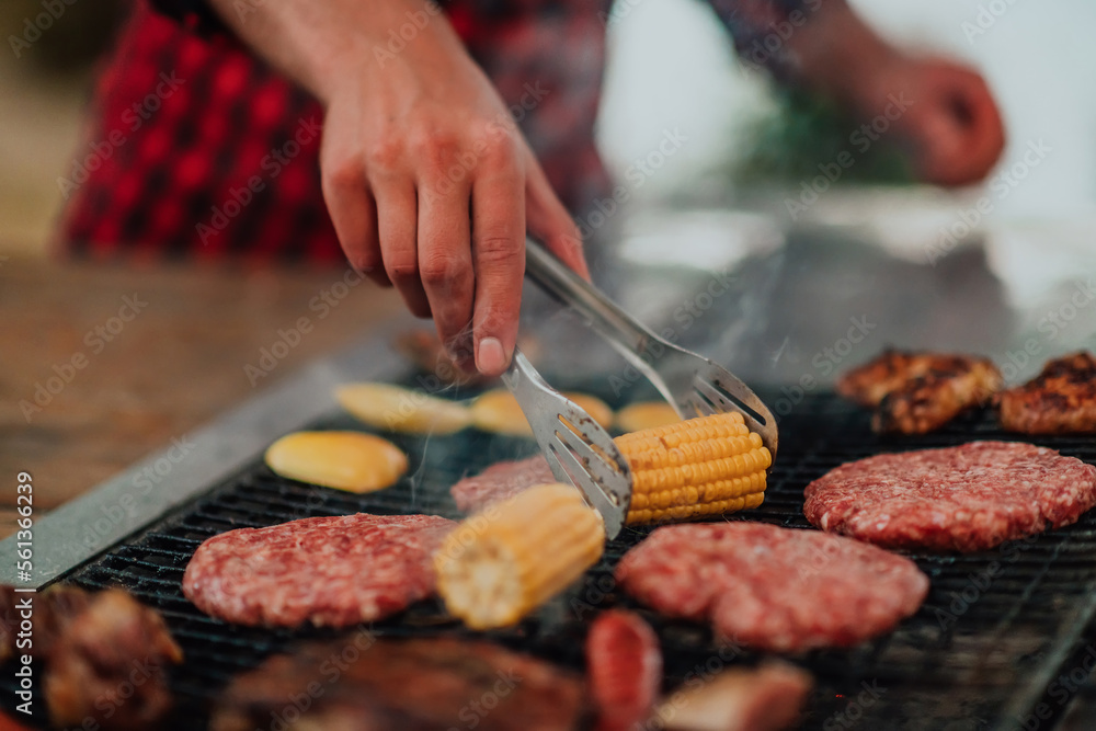 A man preparing a delicious dinner for his friends who are having fun by the river in nature A man preparing a delicious dinner for his friends who are having fun by the river in nature