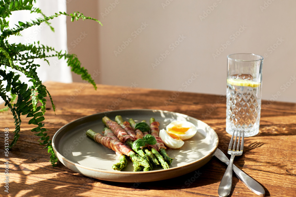 Fresh asparagus wrapped in bacon and grilled, served with egg benedict. Healthy food. Fresh asparagus wrapped in bacon and grilled, served with egg benedict. Healthy food.