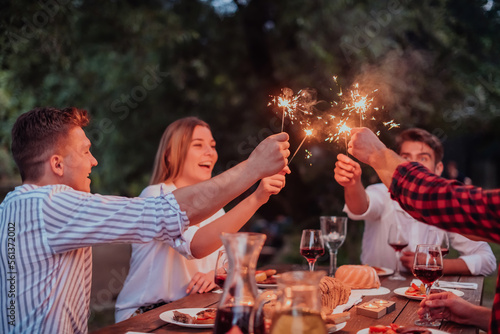 Photography Group of happy friends celebrating holiday vacation using sprinklers and drinkin