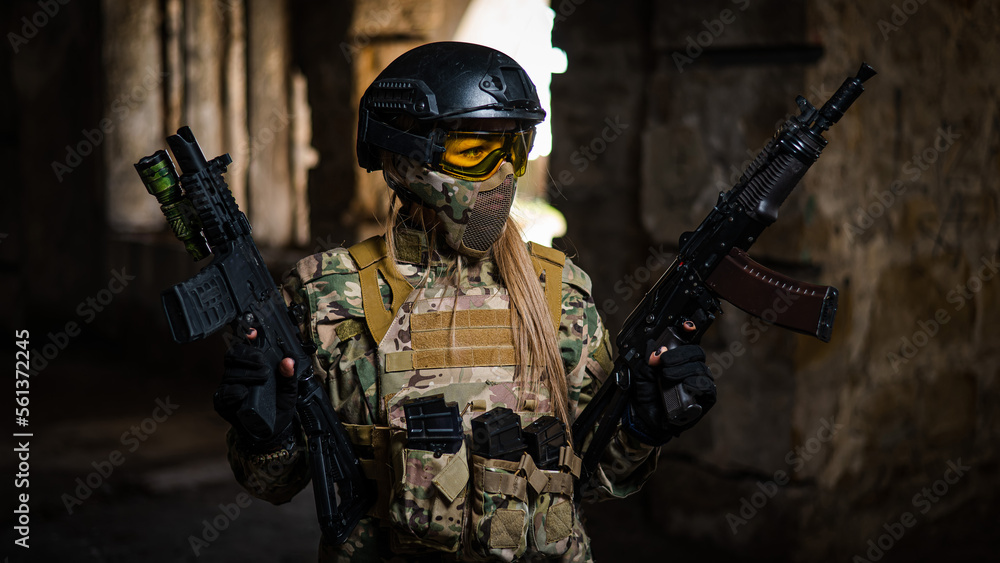 A woman in an army uniform holds a firearm in an abandoned building. A woman in an army uniform holds a firearm in an abandoned building.