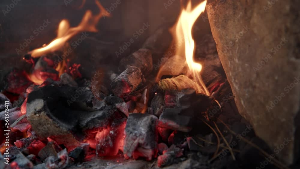 close up view of kindling for fire that lights up while lying on coals in nature. View of campfire in nature, smoke rises from fraying branches and coal. close up view of kindling for fire that lights up while lying on coals in nature. View of campfire in nature, smoke rises from fraying branches and coal.