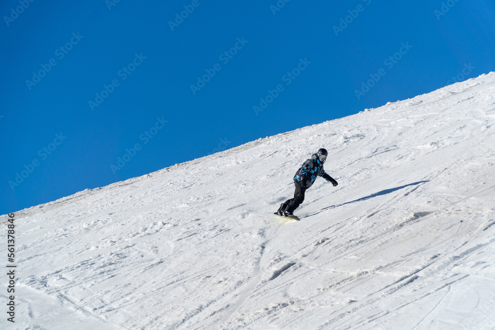 man snowboarding on the mountain on a sunny day