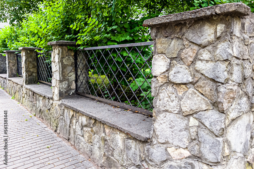 prefab metal fence on concrete foundation pile of stones loose stone construction of houses and yards construction works prefab metal fence on concrete foundation pile of stones loose stone construction of houses and yards construction works