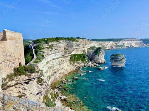 Bonifacio  Corsica  France  view of rocky cliffs of Accore coast  stack of the Grain of Sand   U Diu Grossu  in Corsican  a big rock in the blue sea   hiking climbing path  with seagulls flying ahead