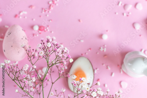 Easter background with colored Easter eggs and blooming flowers on a pink background. easter copy space