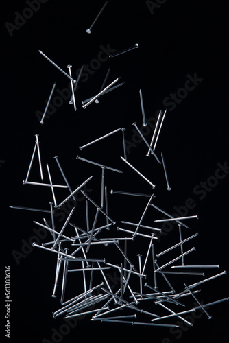 Long Nail fly floating in mid air. Many group screw nails short long metal fall as construction tools. Black background isolated. New Screwdriver Nail fall down unbox steel hardware work © Jade