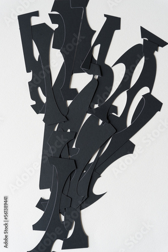 pile of black paper cutouts on blank paper