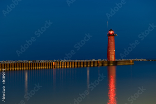 Photography lighthouse on the pier at night with a little light showing from the Beacon with calm waters