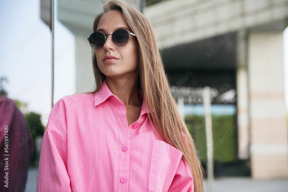 Beautiful young woman in stylish sunglasses on city street Beautiful young woman in stylish sunglasses on city street