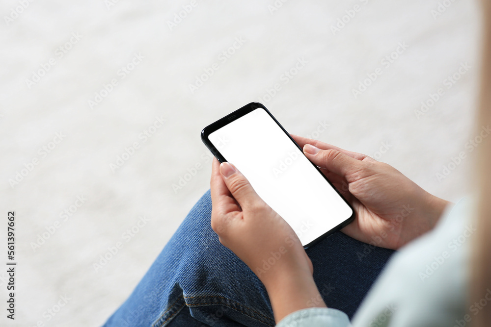 Closeup view of woman with smartphone indoors. Space for text