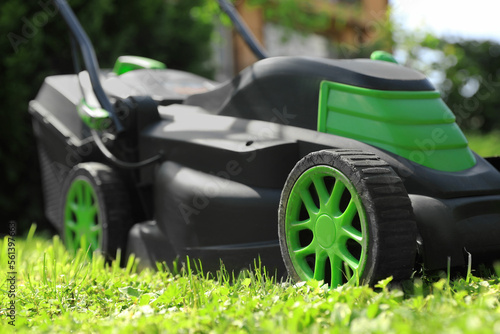 Lawn mower on green grass in garden, closeup