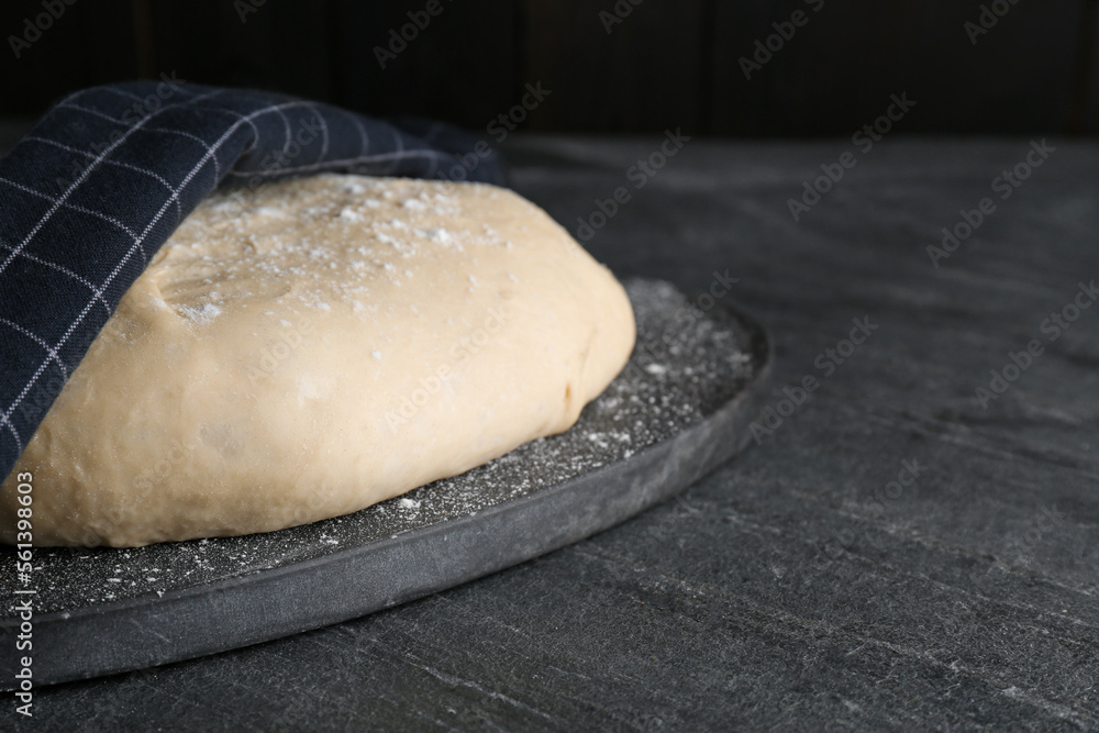 Fresh yeast dough with flour on black table. Space for text Fresh yeast dough with flour on black table. Space for text