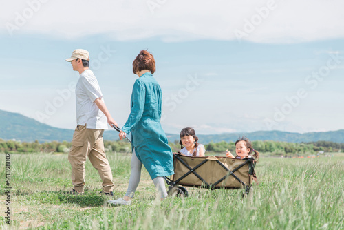春・夏に公園をキャリーカートで歩く家族・ファミリー（子供・幼児・少女） 