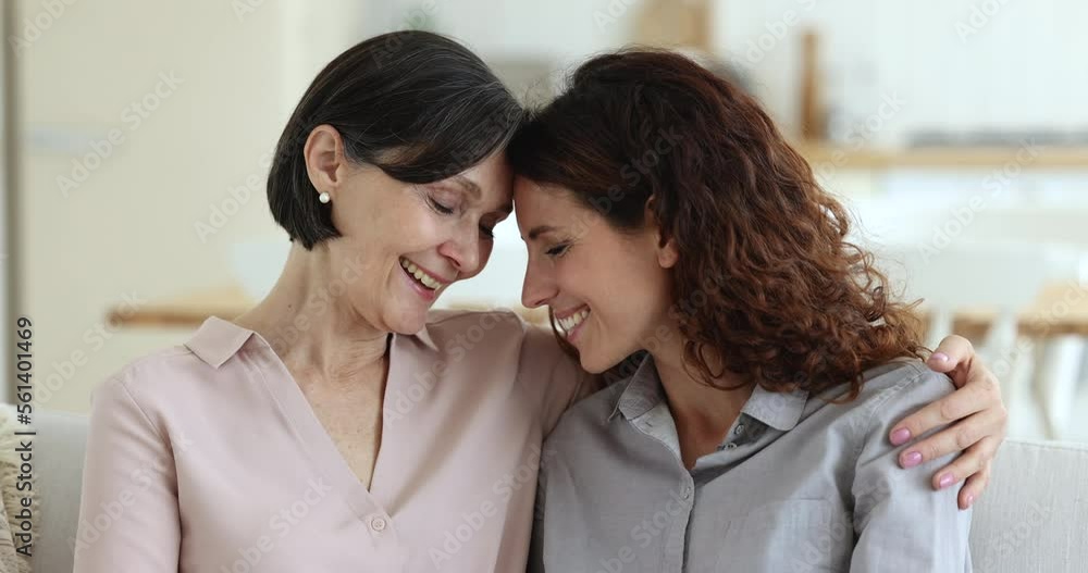 Close up faces older and younger women, portrait of grown up daughter touch foreheads enjoy moment caress, warmth and tenderness with aged loving mommy. Good relations, unconditional love, family ties Close up faces older and younger women, portrait of grown up daughter touch foreheads enjoy moment caress, warmth and tenderness with aged loving mommy. Good relations, unconditional love, family ties