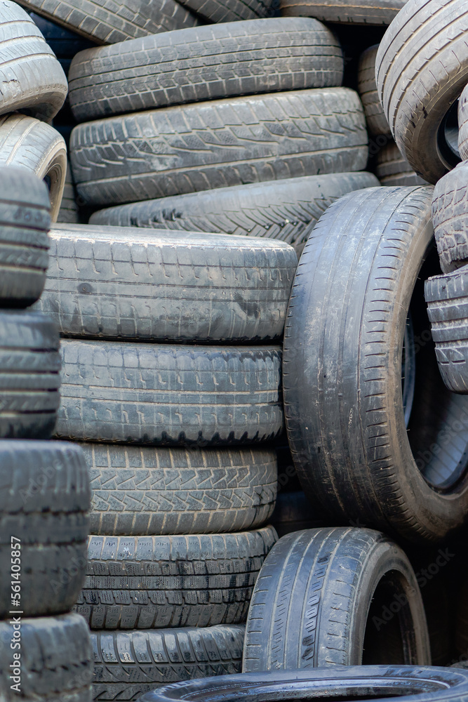 Old used rubber tires stacked with high piles. Tyre dump. Hazardous waste requiring recycling and disposal. Old used rubber tires stacked with high piles. Tyre dump. Hazardous waste requiring recycling and disposal.