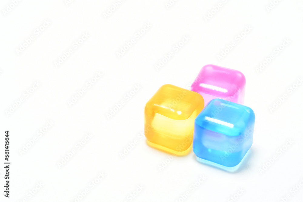Cubos de hielo de colores sobre aislados en un fondo blanco. Espacio para texto al lado izquierdo. Cubos de hielo de colores sobre aislados en un fondo blanco. Espacio para texto al lado izquierdo.