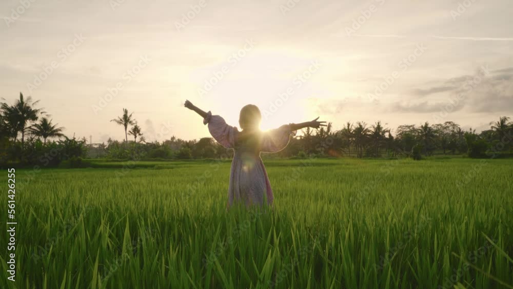 Happy teenage girl walks among the rice fields at sunset. She have a lot of fun, enjoying the beauty of nature and bright colors. 4K Happy teenage girl walks among the rice fields at sunset. She have a lot of fun, enjoying the beauty of nature and bright colors. 4K