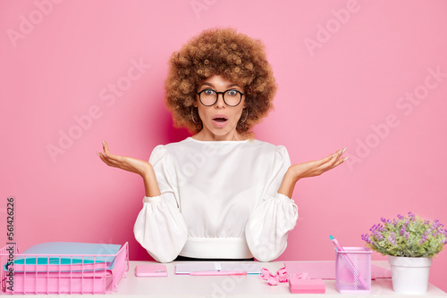 Fotografia Confused office woman worker, spread hands a side in a confusion gesture, opened