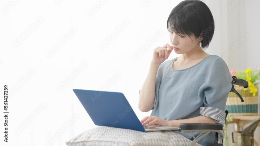 車椅子でノートパソコンを使う若い女性 多様性社会イメージ 車椅子でノートパソコンを使う若い女性 多様性社会イメージ