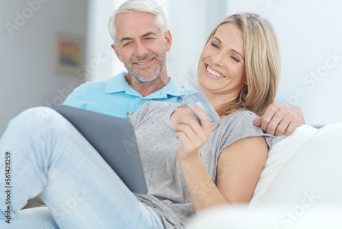 Mature couple, credit card or tablet banking for financial management, investment security or finance in living room. Smile, happy or relax man or woman on technology for house insurance or home loan