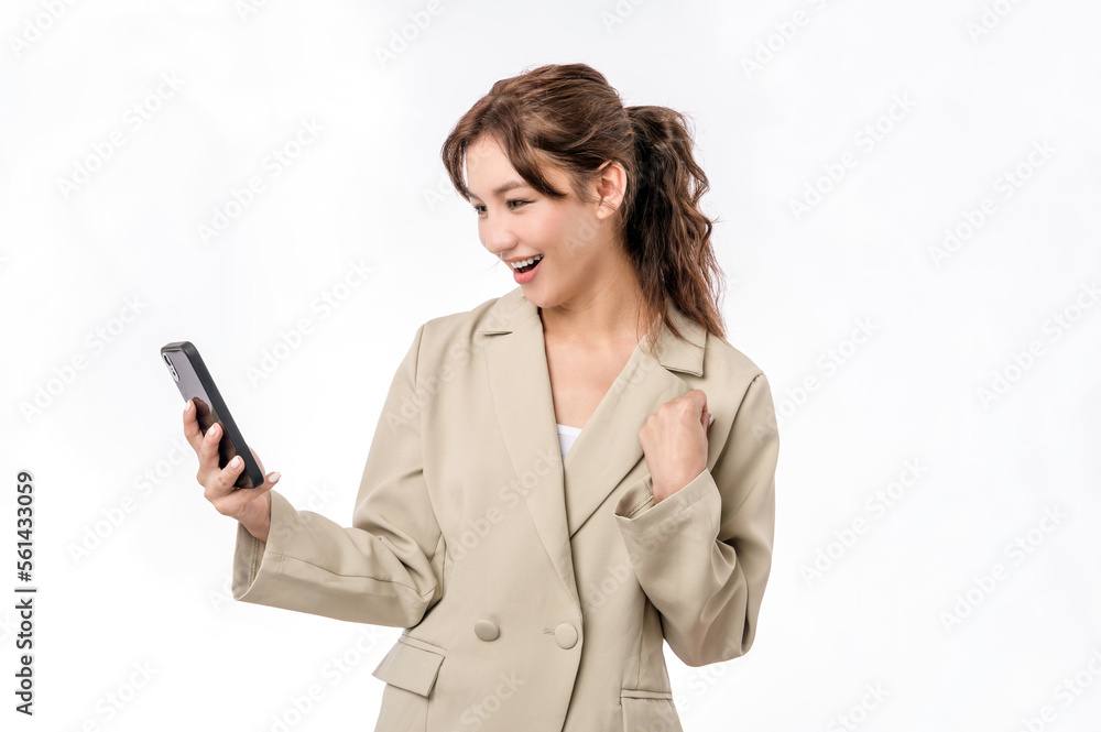 Portrait photo of young beautiful Asian woman in business suit feeling happy or surprise shock and holding smart phone on white background can use for advertising or product presenting concept. Portrait photo of young beautiful Asian woman in business suit feeling happy or surprise shock and holding smart phone on white background can use for advertising or product presenting concept.
