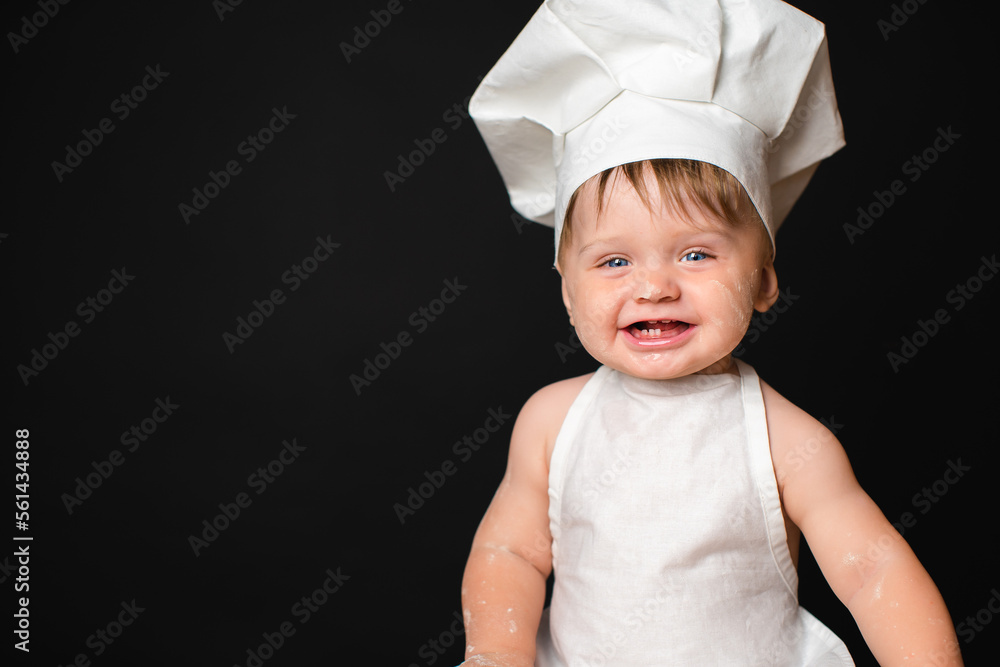 Portrait of laughing little boy in suit of the cook dirty in flour who looking at camera. Copy Space Portrait of laughing little boy in suit of the cook dirty in flour who looking at camera. Copy Space