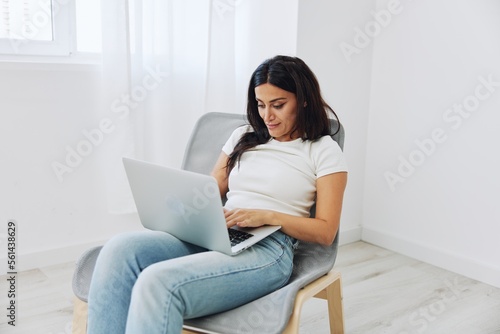 Woman freelancer works in laptop via internet over startup at home sitting on chair, technology in business © SHOTPRIME STUDIO