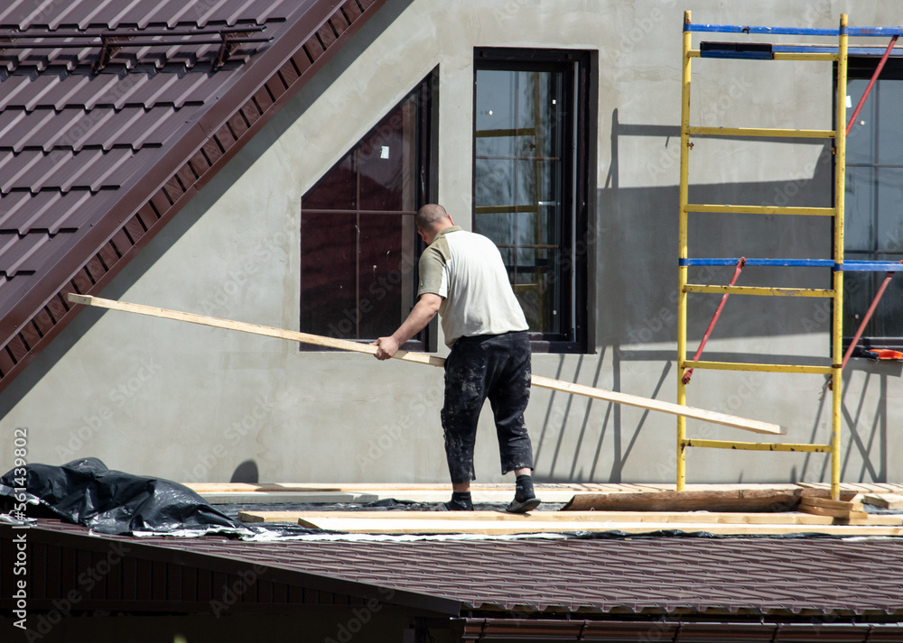 Workers are plastering the walls of the house outside. Cottage Workers are plastering the walls of the house outside. Cottage