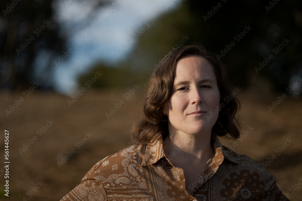 A nonbinary White person expresses themselves outdoors in a park setting. A nonbinary White person expresses themselves outdoors in a park setting.