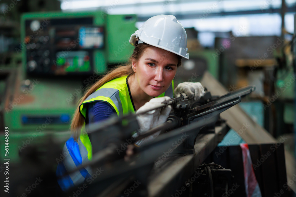 caucasian female engineering worker wearing safety hardhat helmet inspecting auto robot lathe machine to drill components. Metal lathe industrial manufacturing factory caucasian female engineering worker wearing safety hardhat helmet inspecting auto robot lathe machine to drill components. Metal lathe industrial manufacturing factory