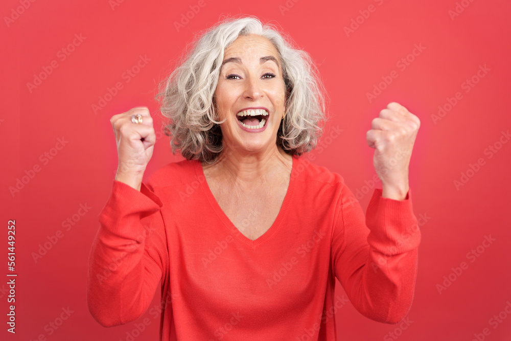 Mature woman celebrating while raising the fists Mature woman celebrating while raising the fists