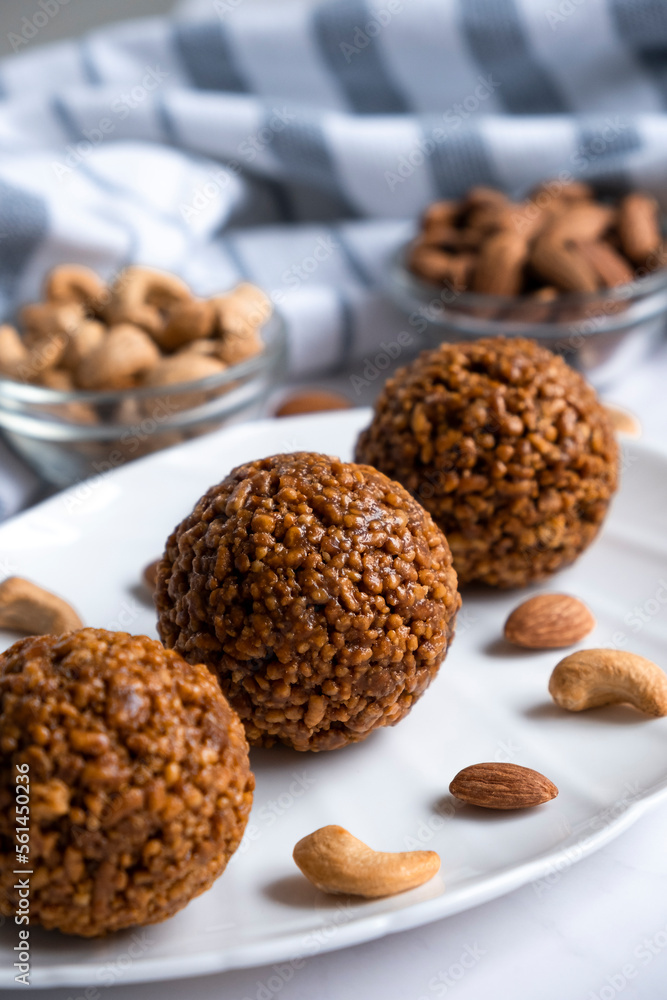 Energy bar nut balls cookie on white plate with almond and cashew. Recipe of simple homemade cookie with nuts full of protein and fats. Ketogenic diet or paleo diet dessert. Energy bar nut balls cookie on white plate with almond and cashew. Recipe of simple homemade cookie with nuts full of protein and fats. Ketogenic diet or paleo diet dessert.