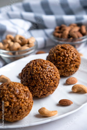 Energy bar nut balls cookie on white plate with almond and cashew. Recipe of simple homemade cookie with nuts full of protein and fats. Ketogenic diet or paleo diet dessert.