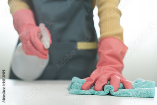 Cleanliness, asian young woman working chore clean up on white table, hand wearing gloves using rag rub remove dust with spray bottle. Household hygiene clean up, cleaner, equipment tool for cleaning.