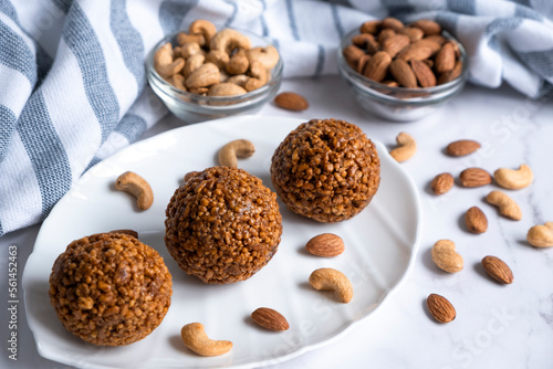 Cookie balls made of biscuit crumbs, cashew and almons nuts and caramel on white plate. Easy recipe of homemade dessert without baking. Bliss balls for tea time.