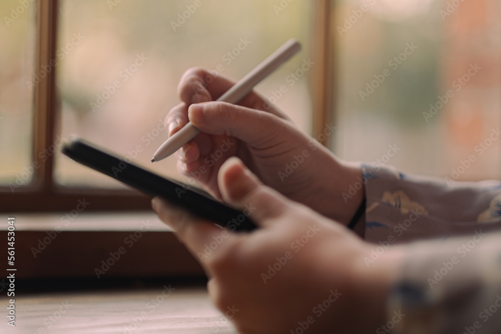 S. setting goals on a tablet while working at a café. S. setting goals on a tablet while working at a café.