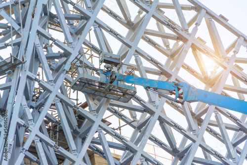 Metal frame lattice building decoration, with tower lift and cradle.