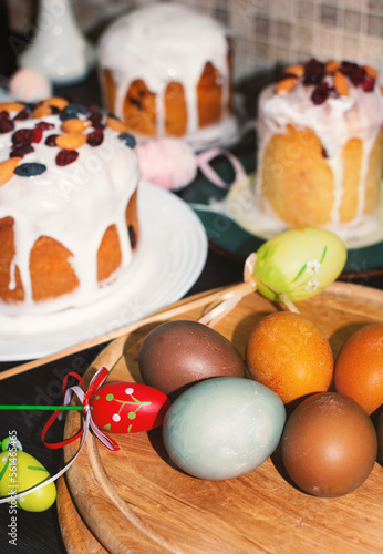 Homemade Easter eggs and cakes on a wooden board. Traditional holiday decoration. Festive Easter background.