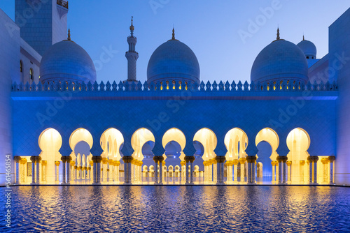 Sideview during the blue hour of the majestic Sheik Zayed mosque in Abu Dhabi reflected on the water