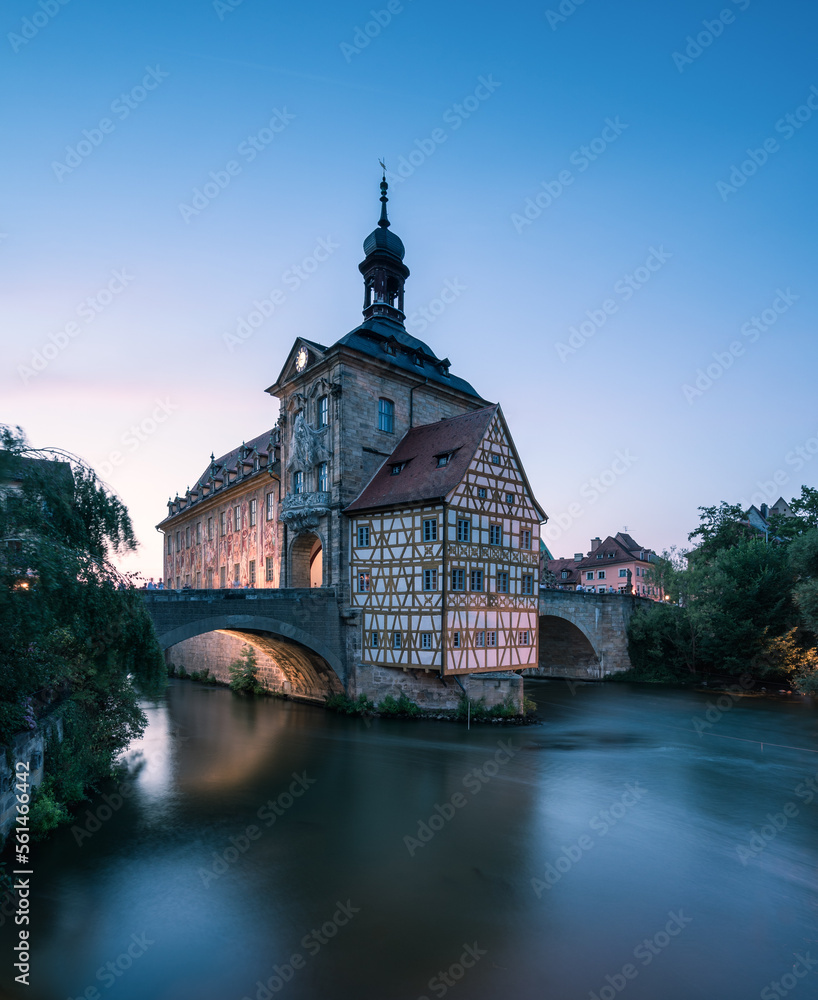 Altes Rathaus mit Fachwerk in Bamberg mit Brücke im Abendlicht.