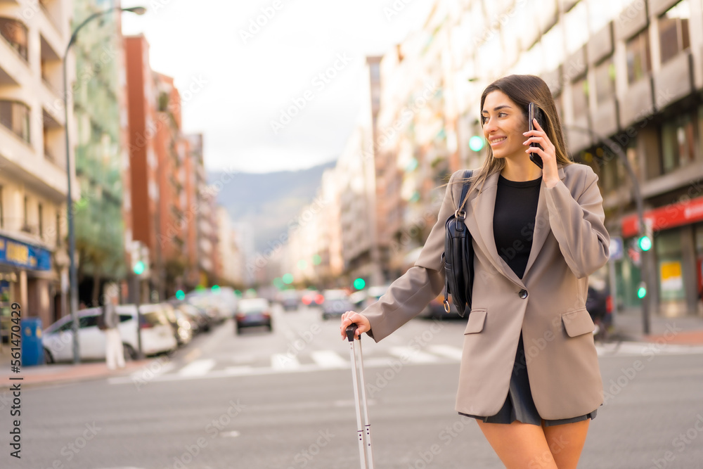 Tourist woman with suitcase in the city smiling, concept vacations, lifestyle, with phone