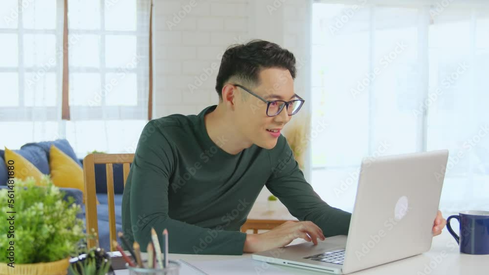 Smiling handsome asian businessman working remotely from home. He is webinar video conference Smiling handsome asian businessman working remotely from home. He is webinar video conference