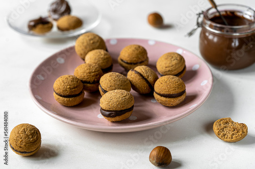 Hazelnut biscuits baci di dama or lady's kisses are traditional Italian dessert made as a sandwich with two cookies and chocolate cream.  photo