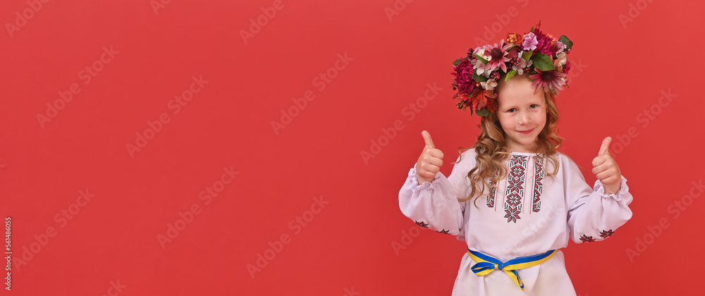 Fototapeta premium a girl child in a Ukrainian national costume. with a wreath of flowers on his head. copy space