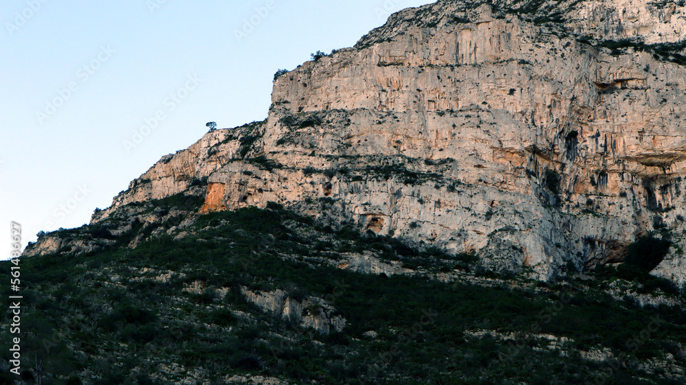 White mountain, sheer cliffs, stones, mountain vegetation, pine trees, beautiful unique landscape, Mount Montgo in Spain Alicante 